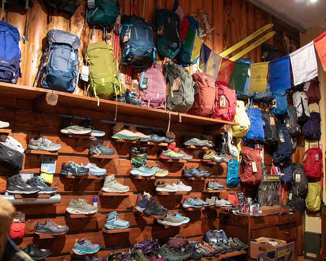 Foto di scarpe e zaini per trekking e cammini, disponibili da Passion Sport a Torino