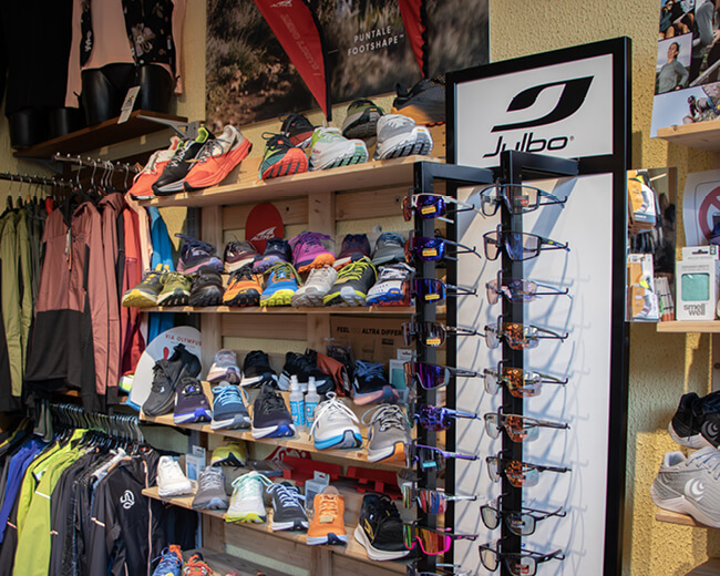 Foto dell'assortimento di scarpe Altra Running e occhiali da sole tecnici Julbo, disponibili da Passion Sport a Torino